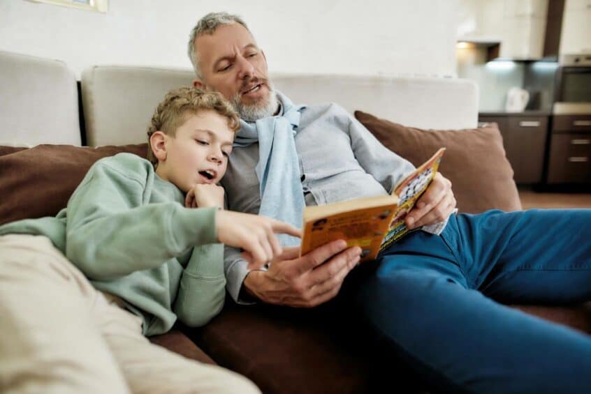 Grandfather and grandson reading a book together